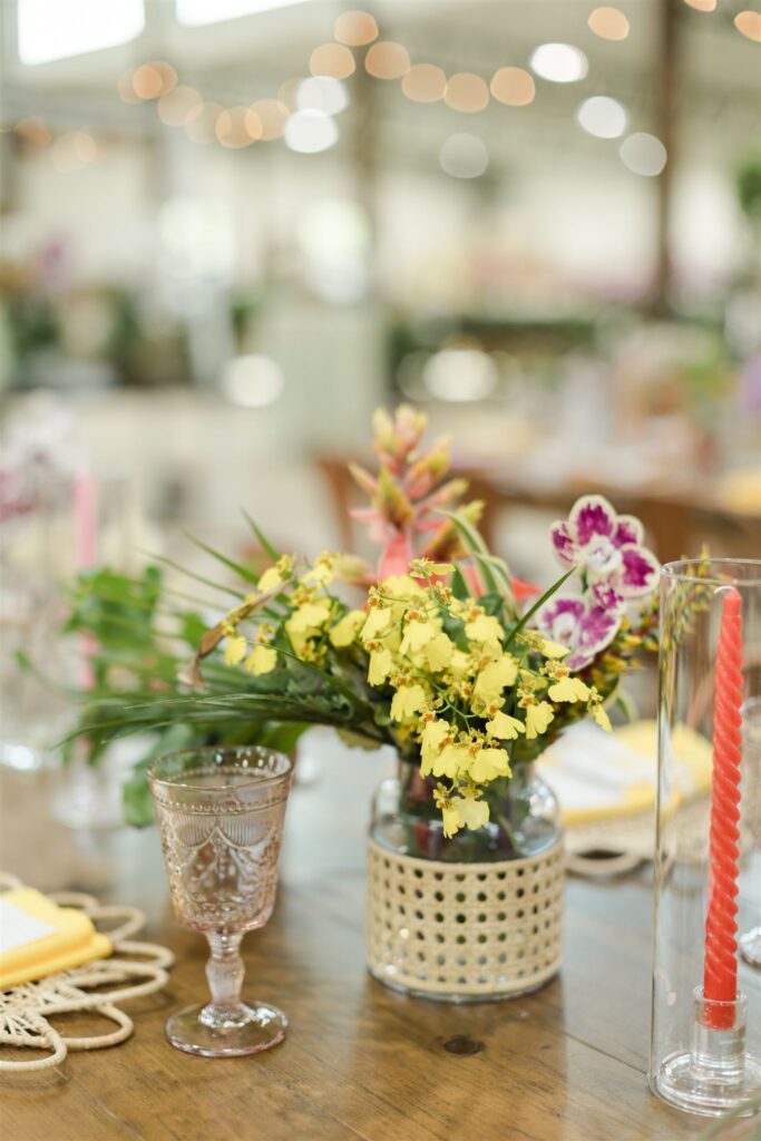 Close-up of vibrant tropical floral arrangement with orchids and lush greenery by Sarandipity Florals at Blooming Freedom venue