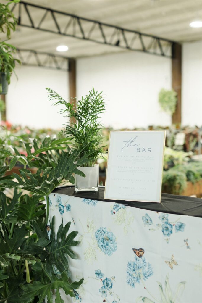Close-up of bar sign with greenery decorating the side of a bar cart at Blooming Freedom event in Palm City