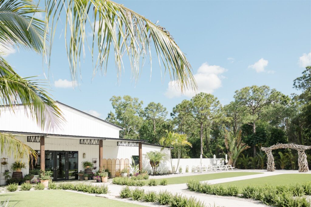 Exterior view of Blooming Freedom event venue in Palm City showing bright white building surrounded by lush tropical greenery